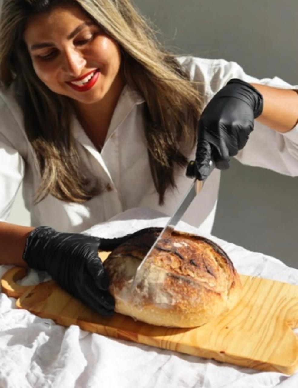 Sara cortando um pão de fermentação natural recém-saído do forno