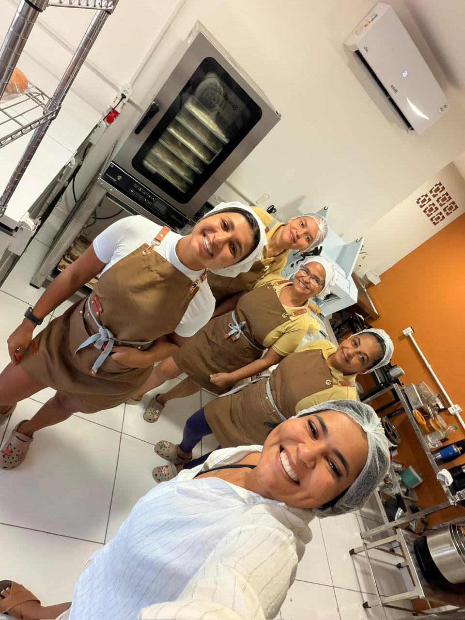 A equipe da Padoca da Sara em frente ao forno do espaço de produção